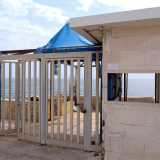 Entriamo ora nel lido varcando un cancello, (il cui celeste � stato divorato dalla ruggine), affiancato dalla finestrella della reception che ci regala un nostalgico scorcio vista mare